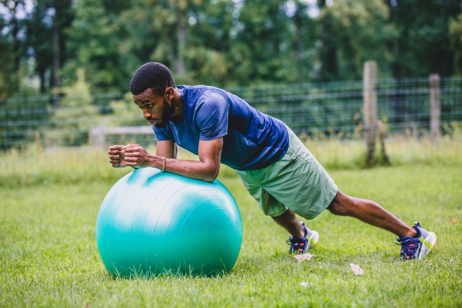 Fitness trainer Ifa Simmonds performing a plank on an exercise ball.
